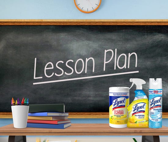 Classroom chalkboard with "Lesson Plan" text and cleaning products displayed in front.