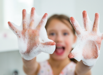 a girl showing her hands with a soap