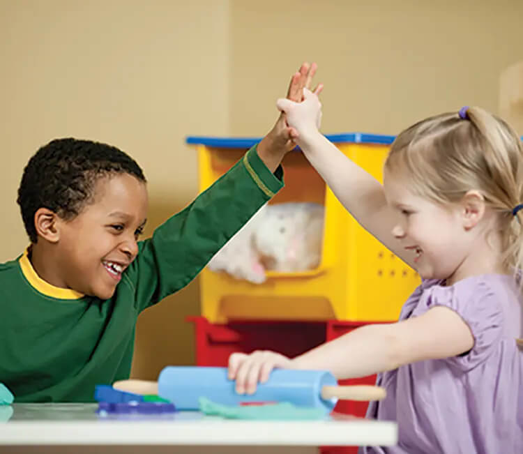 Children holding hands and rolling out salt dough