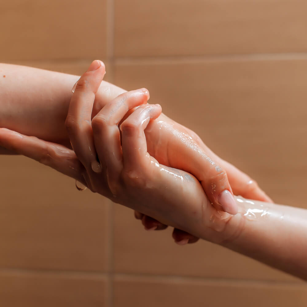 Dos manos llenas de lubricante tomandose fuerte.