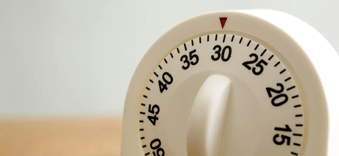 A kitchen timer on a wooden counter set to 30 minutes.