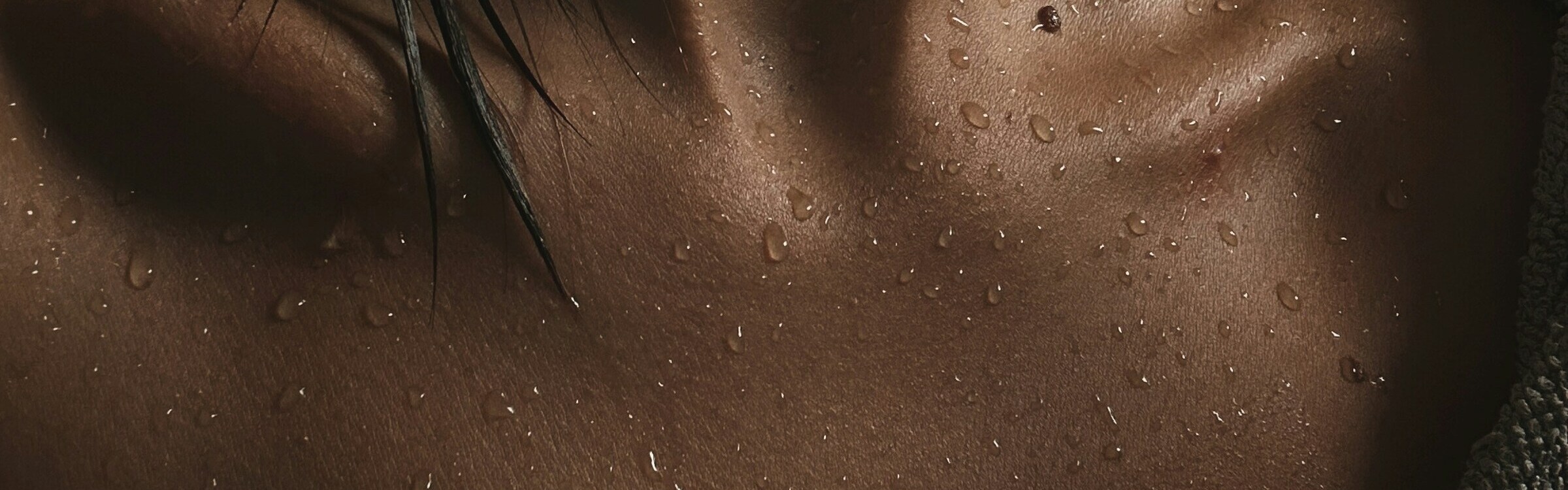 Water droplets on a person’s upper chest and collarbone.