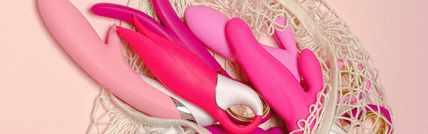 A bag containing various pink and white vibrators displayed together.