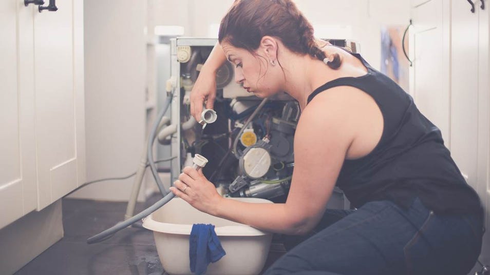 Image d'un femme qui répare une machine à laver