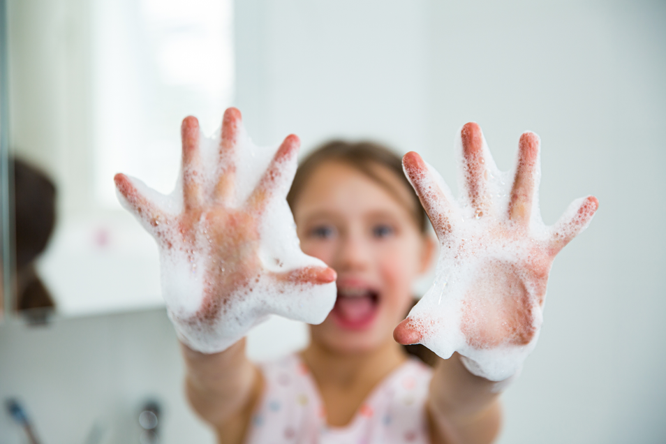 a girl showing her hands with soap