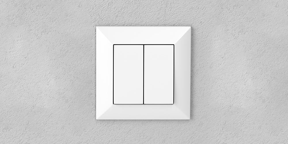 White double light switch on a textured gray wall.