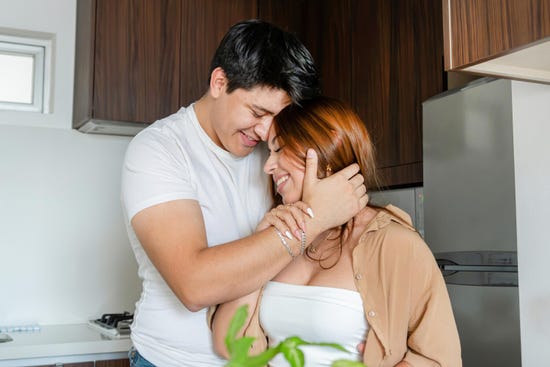 Una pareja en un momento romantico abrazados en la cocina