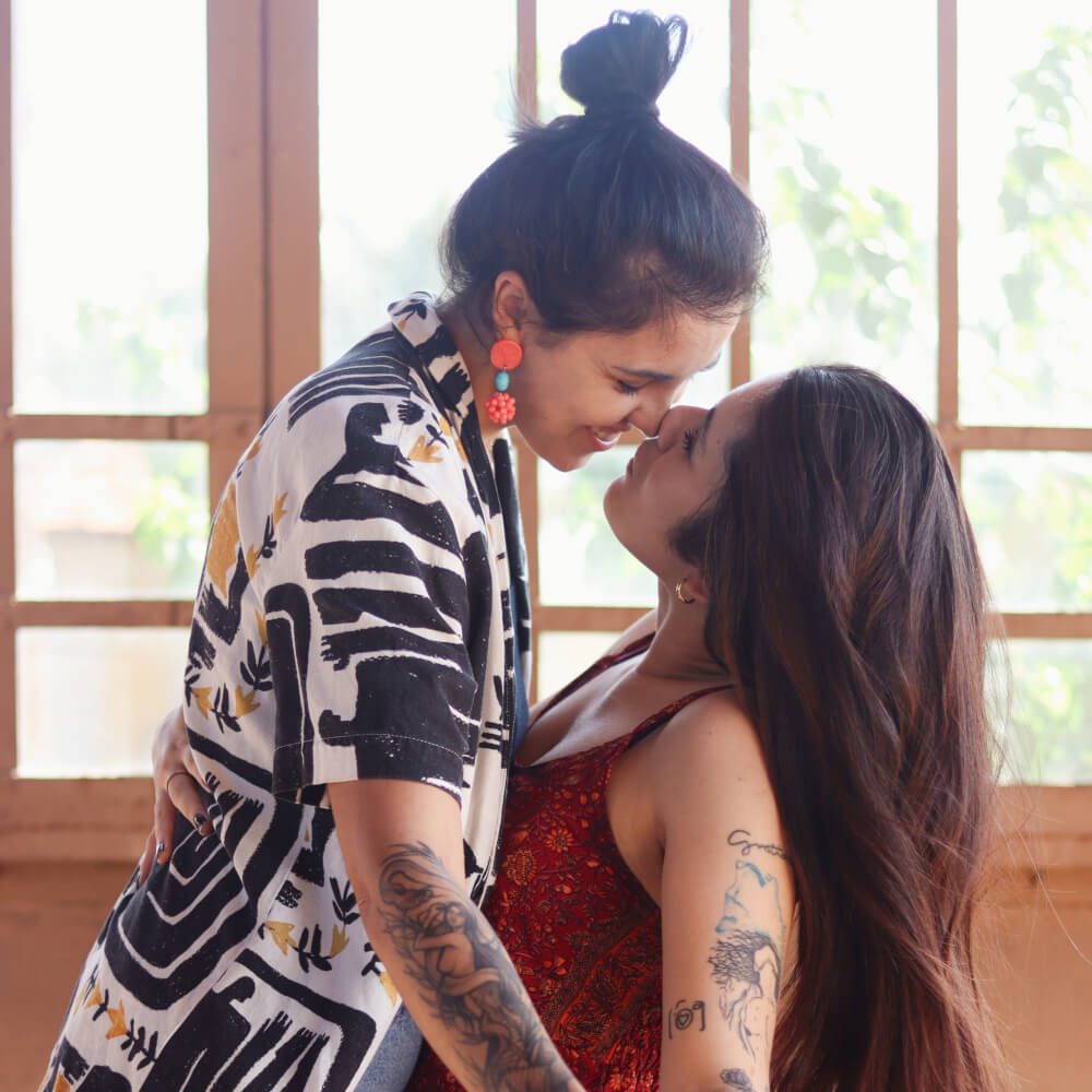 Dos mujeres bailando y besandose