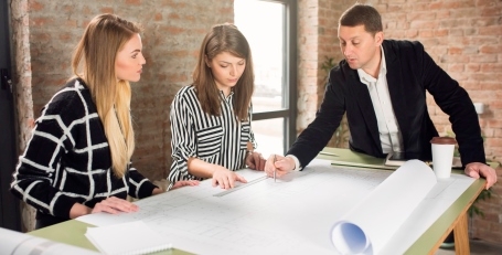 Three office workers looking at paperwork