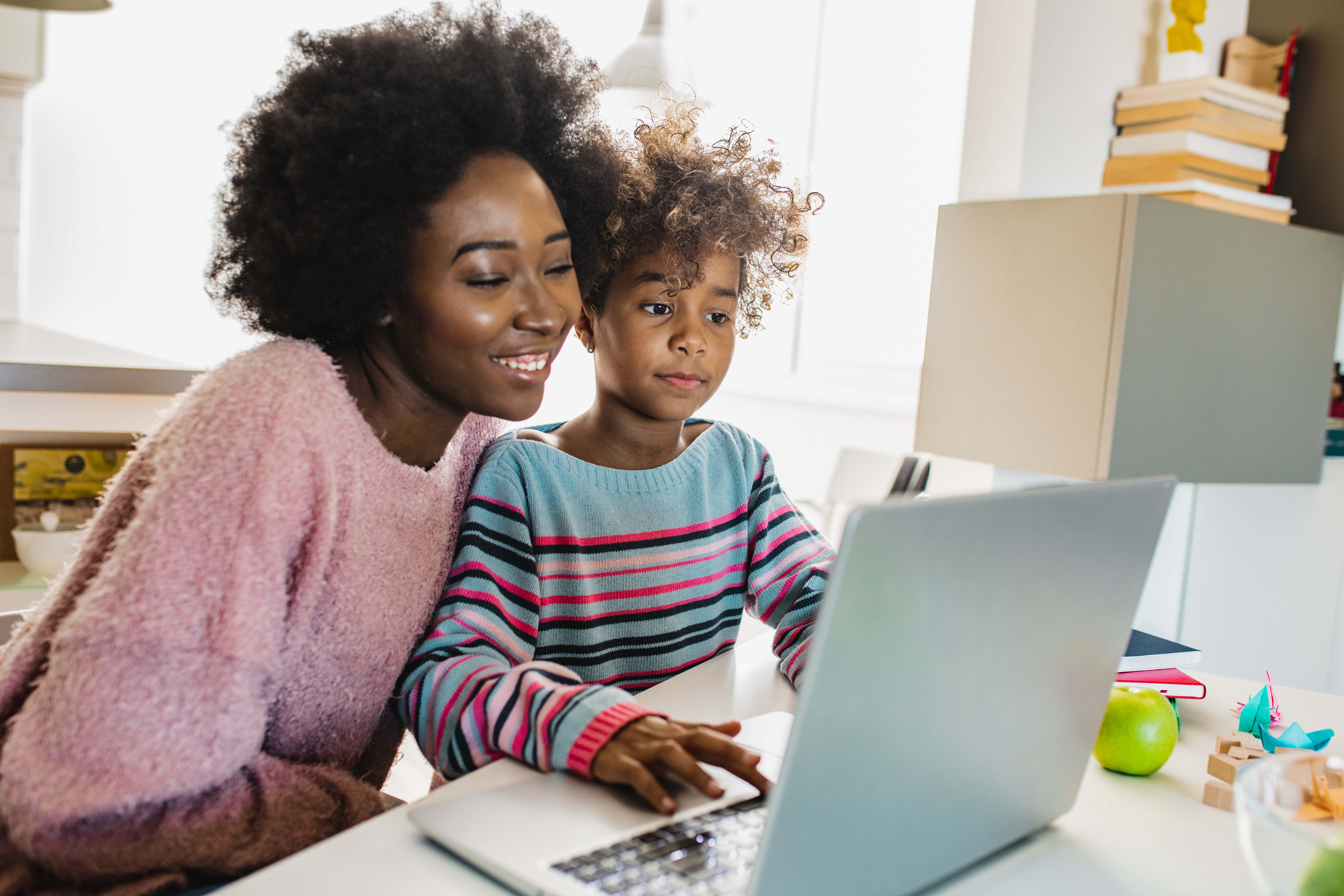 A woman and her daughter searching information online.