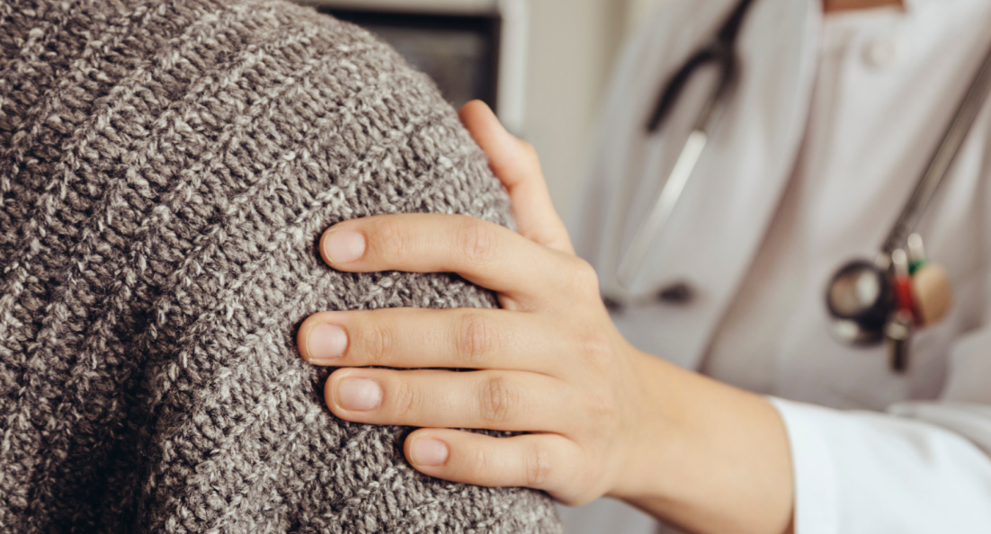 Bild på en hand som håller på axeln