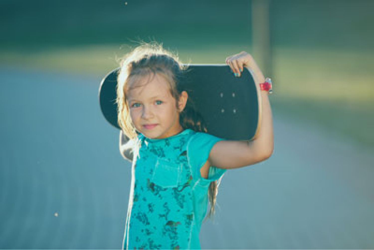 Liten tjej som håller i en skateboard