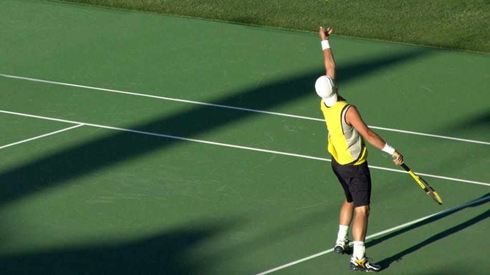 A person preparing to serve a tennis ball
