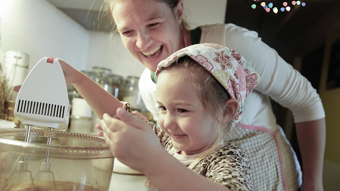 الأم وطفلها يستمتعان أثناء تحضير شيء ما في المطبخ