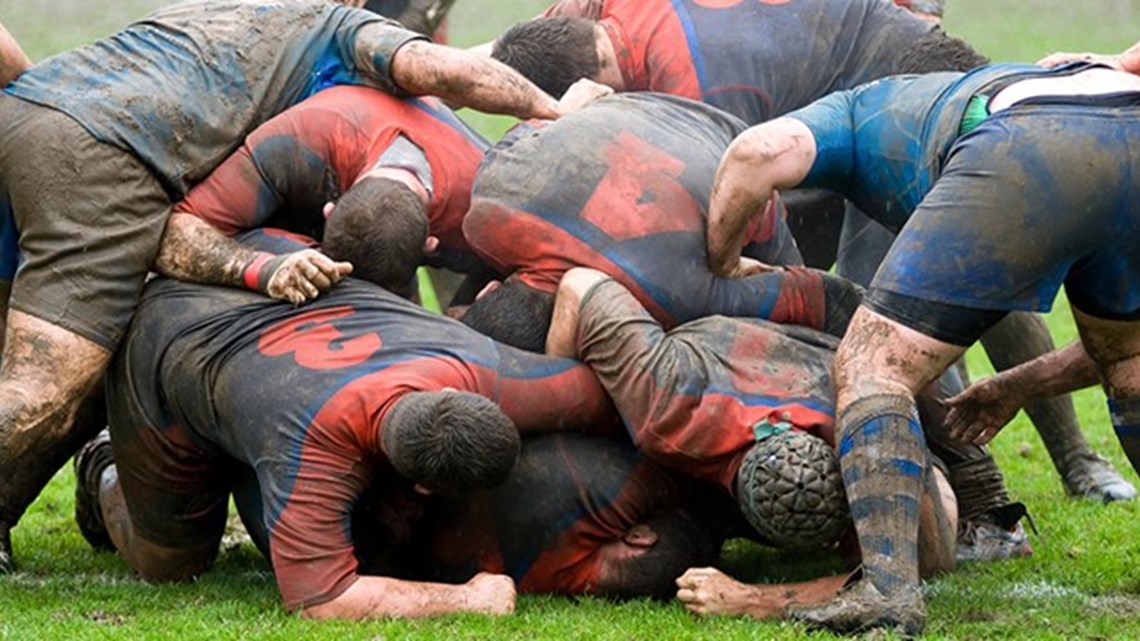 rugby players playing rugby but with muddy kits