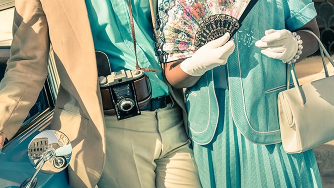 زوجان عتيقان يتصوران بجوار سيارة