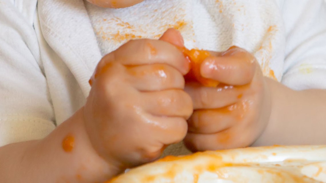 يد الطفل تسحق الطعام