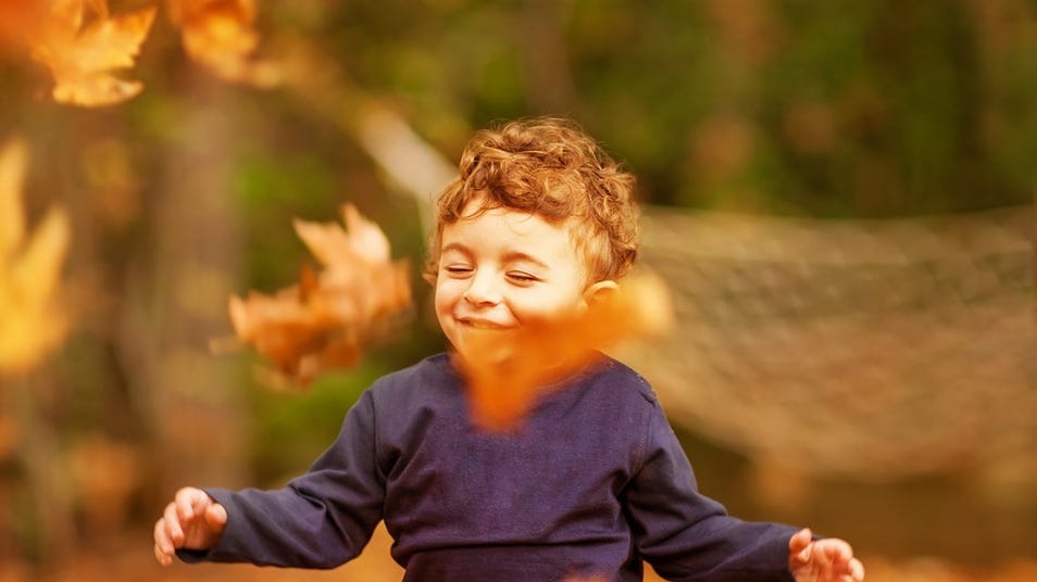 a child being happy in the autumn season
