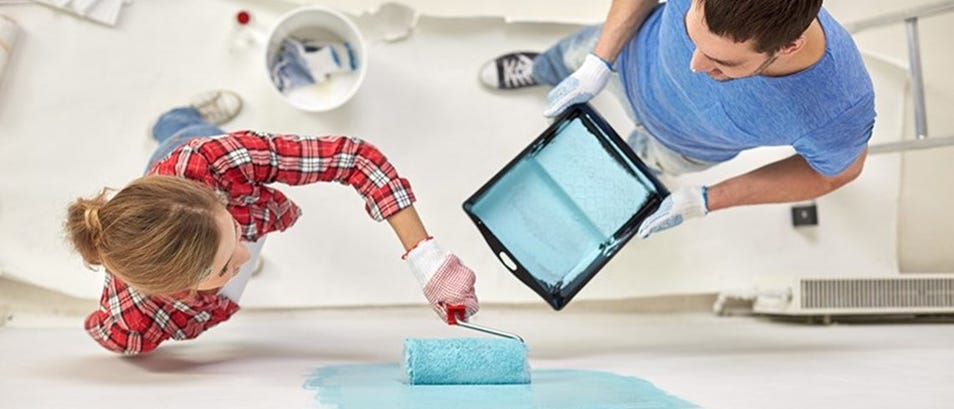 a women and a man painting a wall together