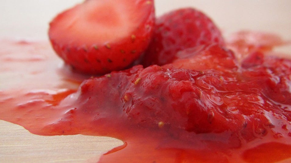 Smashed strawberries with juice on a surface