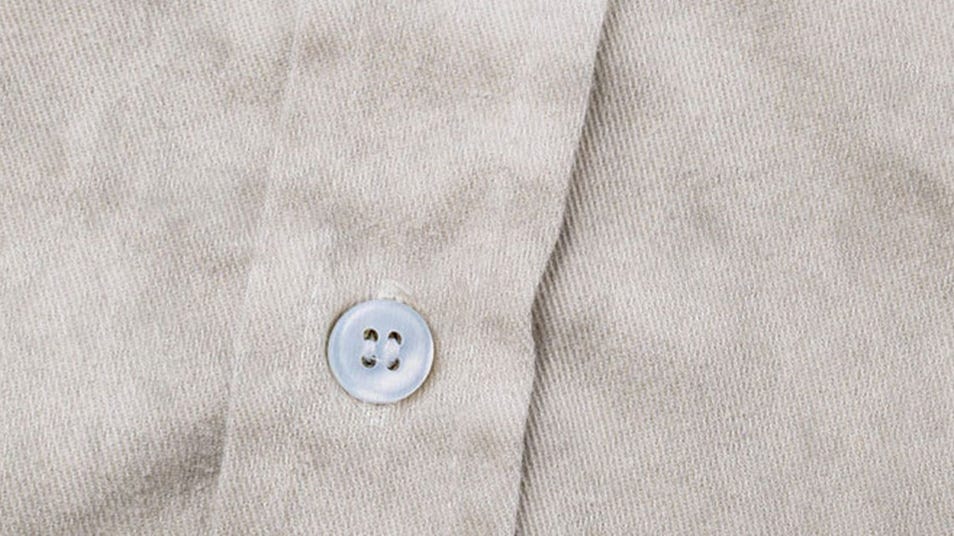 A close-up of a beige shirt button