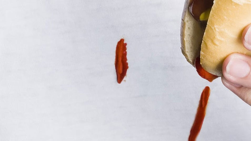 Ketchup dripping from a hot dog bun onto a white shirt