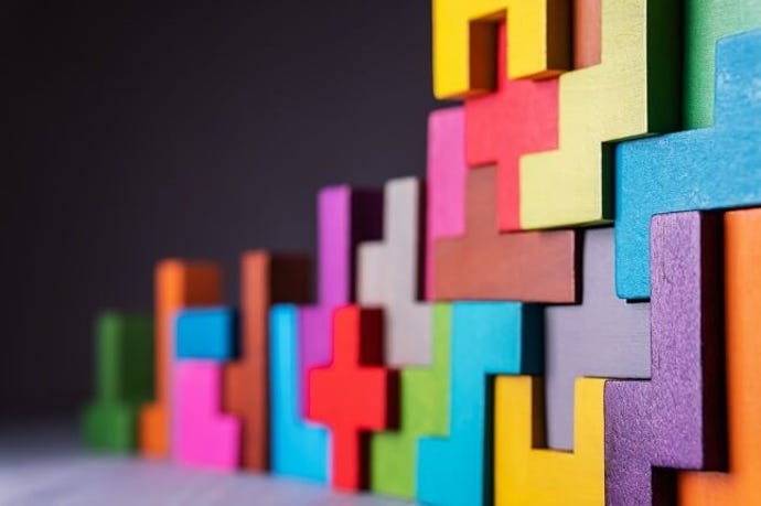 Multi-colored blocks of different shapes put together to create a wall.