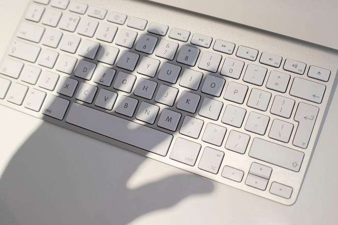 Hand casting threatening shadow on keyboard