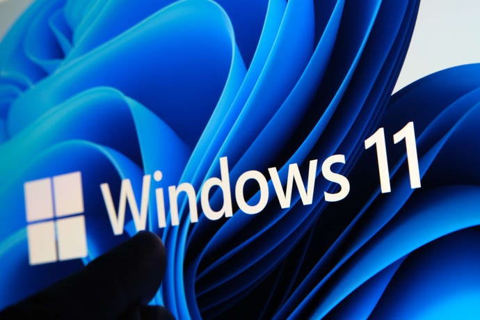 Windows 11 logo seen on the screen of tablet and user pointing at it with finger