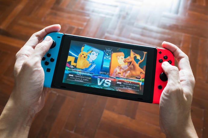 an image of a person holding a Nintendo switch and playing a Pokemon game.
