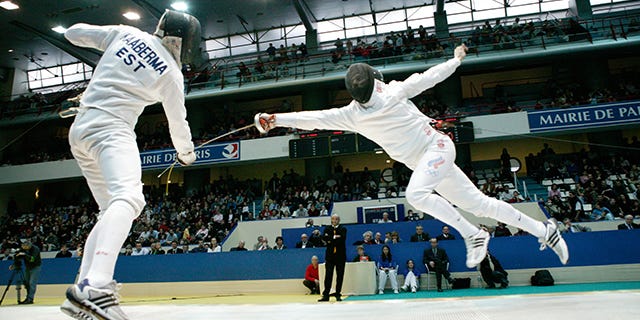 Fencer leaps through the air as his opponent steps aside to evade his thrust
