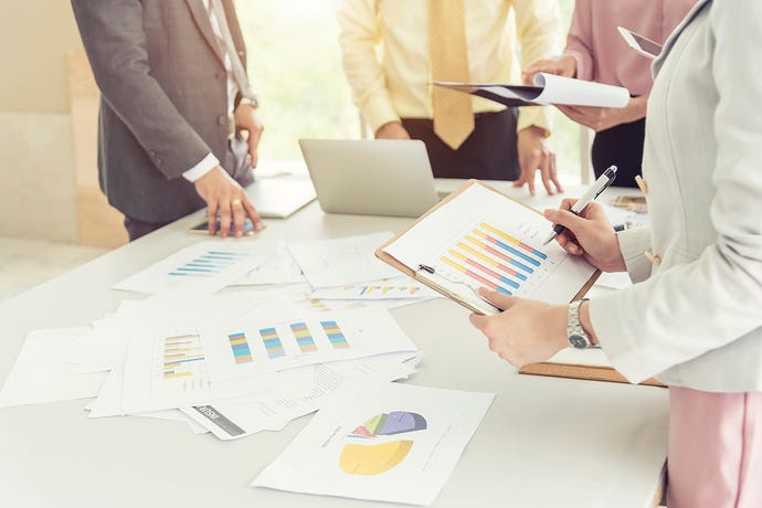 Photo of cut-off business people brainstorming about new project with information graph on table