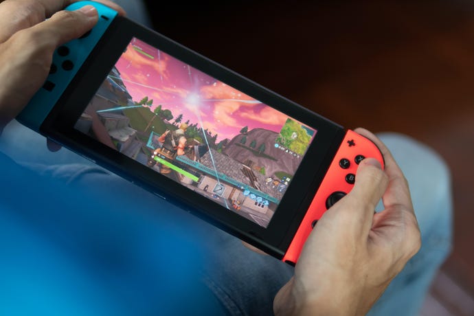 Hands holding a Nintendo Switch playing Fortnite