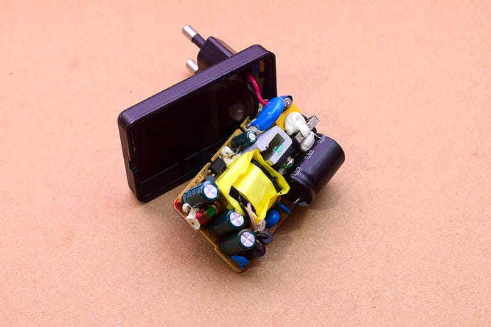 mobile phone charger with innards hanging out, on brown paper background
