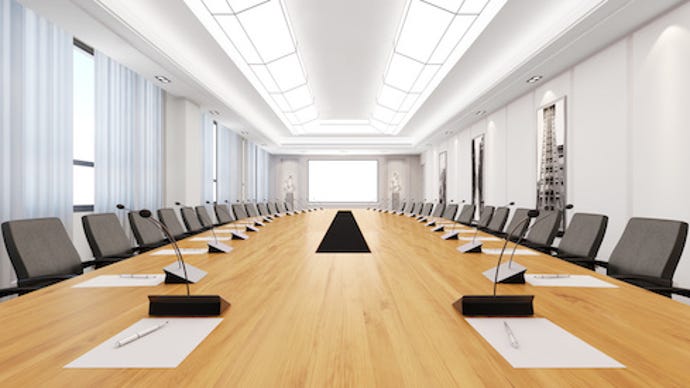 Image of a long boardroom table and chairs