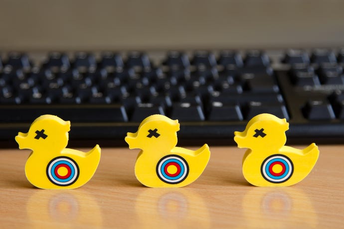 Yellow duck erasers with shooting targets on them in front of computer keyboard