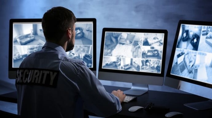 Photo of security professional with computer monitors