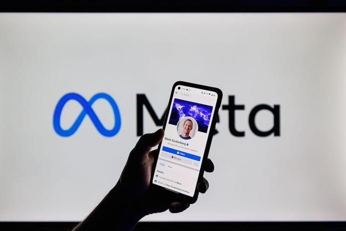 Image of mobile phone with Meta's Zuckerberg amid a backdrop of the Meta logo