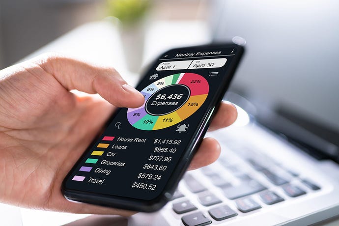 Photo illustration of a man's hand holding a phone running a simulated budgeting fintech app