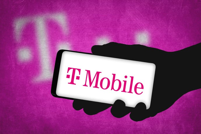 Person holding mobile phone displaying T-Mobile logo