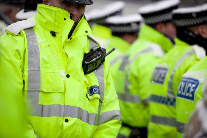 A close-up of an officer of the Manchester Police wearing a yellow jacket