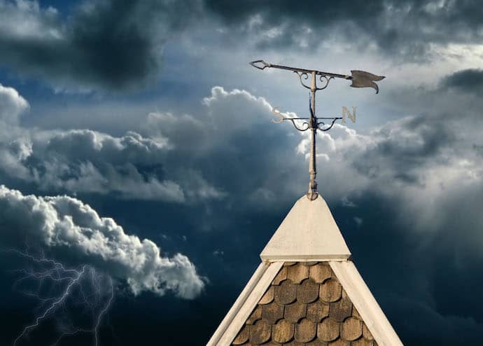 Weather vane with a cloudy sky indicating an approaching storm