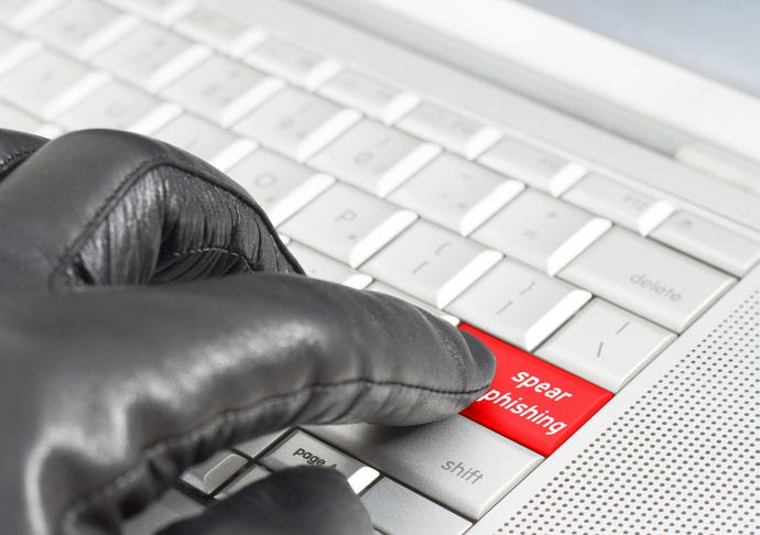 Spear -phishing concept with hand wearing black leather glove pressing keyboard key
