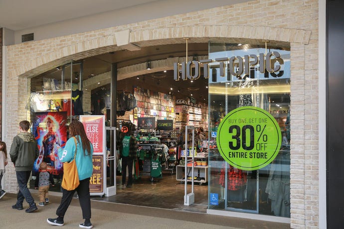 An image of the outside of the store "Hot Topic" inside of a mall.