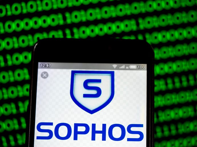A photo illustration of Sophos logo displayed on a smartphone against computer code backdrop