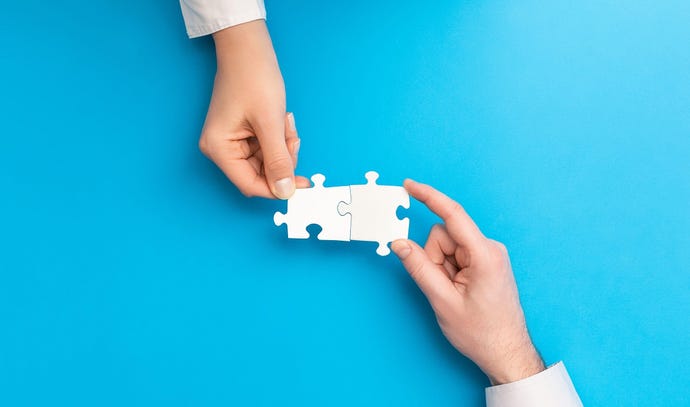 Two hands, each holding a puzzle piece