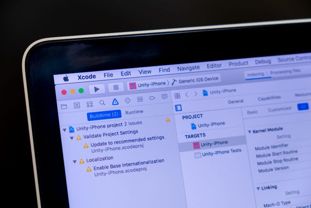 close up of Xcode application on laptop screen with black background.