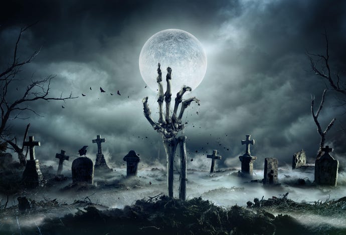 Skeleton hand rising out of grave at a cemetery amid an ominous background