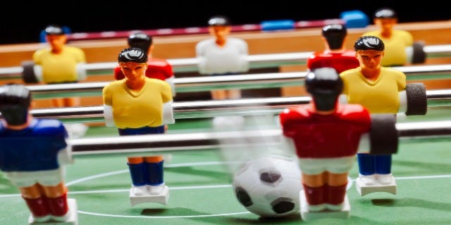 a tabletop fooseball set with mini soccer ball
