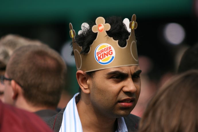 agitated man wearing burger king crown 